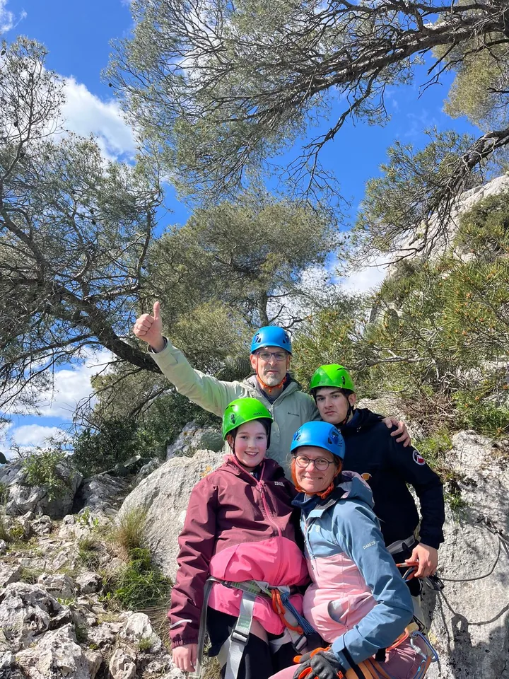 Family group in helmets smiling during a via ferrata day in Provence.